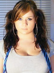 Busty Teen Tara poses in her kitchen wearing a tartan skirt and bra